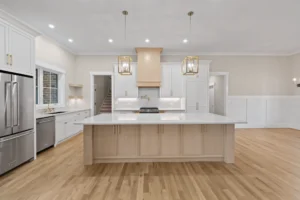 Luxury open-concept kitchen in Lakenridge Builders' 2025 Gold Award home featuring custom cabinetry, large center island, high-end appliances, hidden walk-in pantry, and gorgeous hardwood floors