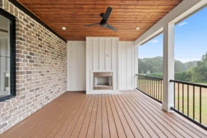 Expansive vaulted screened porch with stone gas-log fireplace, outdoor living area, and ceiling fan at Lakenridge Builders' 2025 Parade of Homes Gold Award-winning home