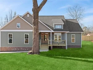Front exterior of new construction home in Brown Summit, NC by Lakenridge Builders Inc., featuring covered porch.