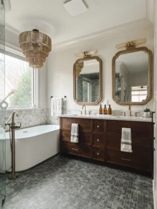Custom dark walnut double vanity with marble countertop, brass fixtures, and arched mirrors in luxury Greensboro bathroom remodel by Lakenridge Builders.