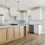 Open-concept kitchen in Brown Summit home with walk-in pantry, modern cabinetry, and LVP flooring by Lakenridge Builders Inc.