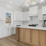 Bright, open-concept kitchen featuring custom cabinetry, quartz countertops, and modern lighting designed for both functionality and everyday family living.