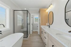 Spa-like master bathroom with dual vanities, premium finishes, and a spacious walk-in shower showcasing a clean, modern design aesthetic.
